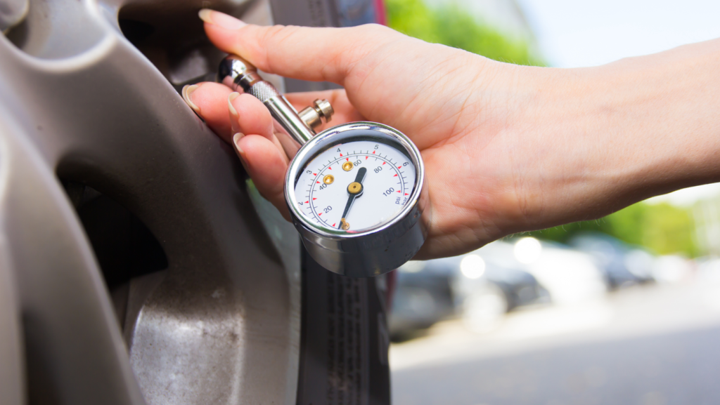 A person checking their tyre pressure giving driving tips on how to stay safe 