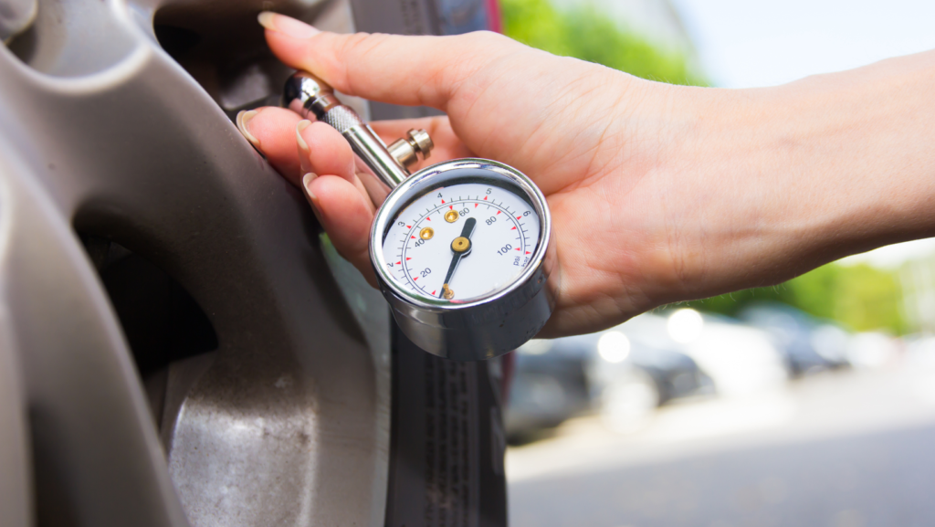 A tyre being checked for pressure with a pressure gauge 